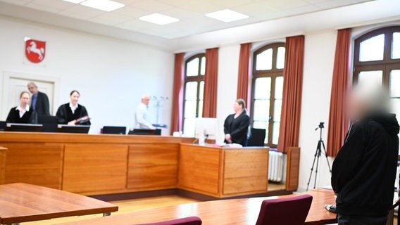 Der 82-jährige Angeklagte (r) steht im Saal 116 des Landgerichts Aurich, wo ein Prozess wegen Drogenhandels verhandelt wird. © dpa-Bildfunk Foto:  Lars Penning/dpa