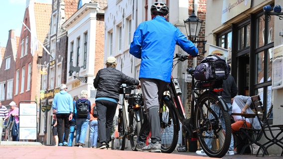 Radreisende sind am ersten Mai-Wochenende bei gutem Wetter in der Altstadt von Leer unterwegs. © dpa Foto: Lars Penning