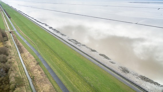Auf einer Luftaufnahme ist ein langer Deich der Aussenems bei Emden zu sehen. © dpa - Bildfunk Foto: Sina Schuldt