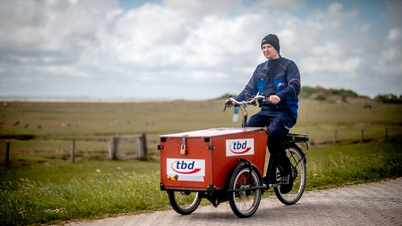 Der Handwerker Hanko Darmstädter ist auf der Insel Baltrum mit einem Lastenrad unterwegs. © Ole Cordsen/tbd Foto: Ole Cordsen