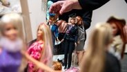 Bettina Dorfmann, Barbie-Puppen-Sammlerin, baut die Ausstellung «Busy girl - Barbie macht Karriere» im Ostfriesischen Landesmuseum auf. © dpa-Bildfunk Foto: Sina Schuldt