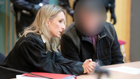 Der Angeklagte sitzt vor Prozessbeginn mit seiner Anwältin in der Stadthalle Verden. © dpa Foto: Sina Schuldt