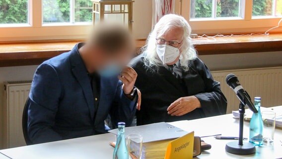 Ein Angeklagter (l) sitzt kurz vor dem Prozess-Auftakt neben seinem Rechtsanwalt. © picture alliance Foto: Lennart Stock