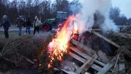 Landwirte haben ein Feuer für eine Mahnwache am JadeWeserPort entzündet. © NonstopNews 