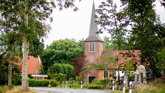 Eine Kirche steht in einem Dorf. © Hauke-Christian Dittrich/dpa Foto: Hauke-Christian Dittrich/dpa