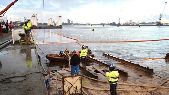 Mitarbeiter der Bergungsfirm bereiten die Bergung des gesunkenen Frachters "Sabine" aus dem Hafenbecken vor. © dpa Foto: Lars Penning