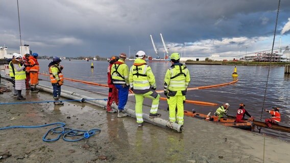 Mitarbeiter einer Bergungsfirma stehen an einem Hafenbecken in Emden. © NDR Foto: Maren Bruns