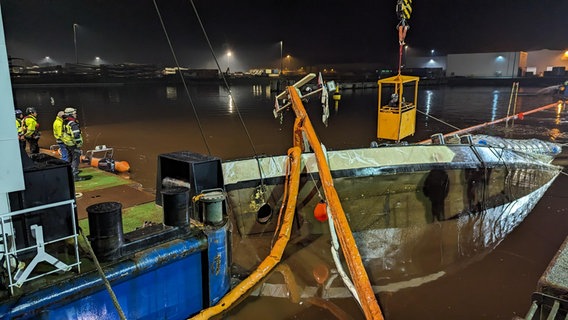 Angestellte einer Bergungsfirma bergen ein gesunkenes Binnenschiff in Emden. © NDR Foto: Sebastian Duden