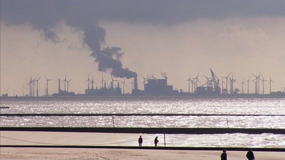 An einer gegenüberliegenden Küste sieht man Fabriken. © NDR 