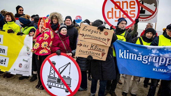 Umweltschützer und Insulaner demonstrieren am Weststrand mit Bannern und Plakaten gegen die geplante Erdgasförderung. © Sina Schuldt/dpa Foto: Sina Schuldt