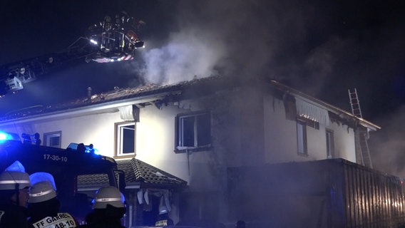 Einsatzkräfte der Feuerwehr löschen ein brennendes Haus. © Nord-West-Media-TV 