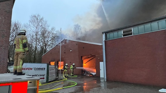 Feuerwehrleute löschen einen Brand in einer Halle eines Reifenlagers in einem Gewerbegebiet in Oldenburg. © Andre van Elten/TNN/dpa Foto: Andre van Elten
