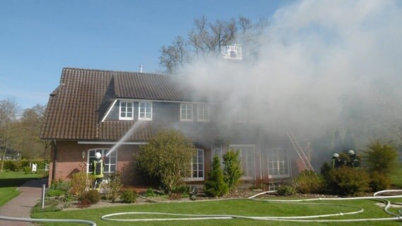 Feuerwehrleute löschen ein brennendes Haus. © Polizei Delmenhorst 