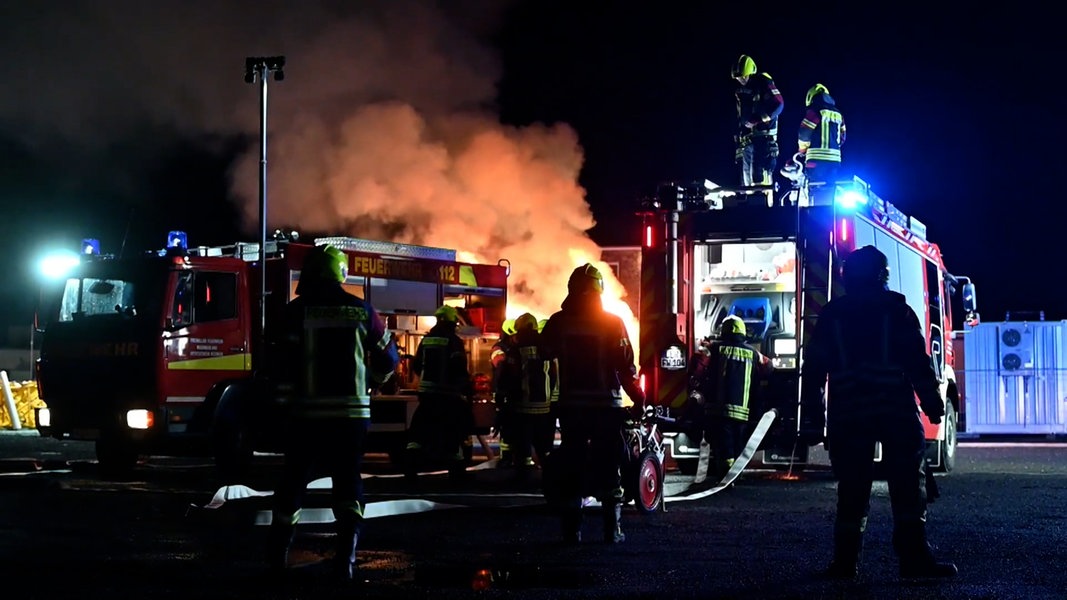 Feuerwehrleute bei einem Einsatz an einem Container mit brennenden Akkus im Landkreis Leer.