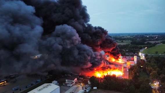 Eine Lagerhalle in Thedinghausen steht großflächig in Flammen, es qualmt stark. © Nord-West-Media/dpa Foto: Nord-West-Media