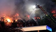 Aus dem verkohlten Dach einer Villa in Cloppenburg schlagen Feuer und Rauch empor. © TV7News 