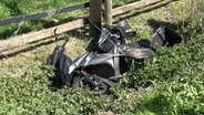 Ein Roller liegt nach einem Zusammenstoß mit einem Lkw in einem Graben. © Nord-West-Media TV 