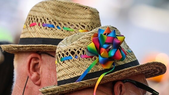 Zwei Teilnehmende tragen beim CSD (Christopher Street Day) Hüte mit Deko in Regenbogenfarben. © dpa-Bildfunk Foto: Focke Strangmann/dpa