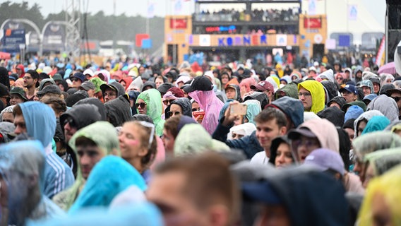 Publikum im Regen mit Regencapes und Kapuzen beim Deichbrand-Festival. © picture alliance/dpa | Lars Penning Foto: Lars Penning