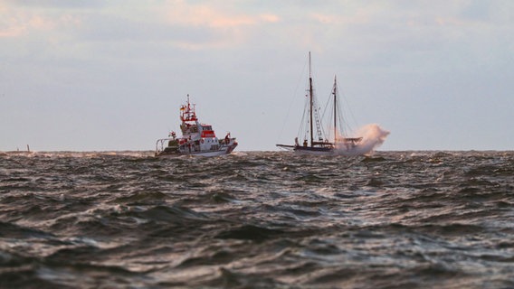Ein Schiff der DGzRS bei einem Rettungseinsatz neben einem Segelschiff in der Nordsee. © DGsRS 
