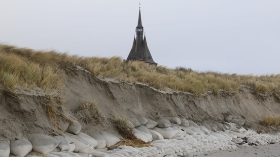 Die zur Stabilisierung eine Düne eingebaute Sandsäcke wurden von den Wellen eines Sturmtiefs freigelegt. © picture alliance/dpa Foto: Peter Kuchenbuch-Hanken