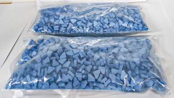 Plastikbeutel mit blauen Ecstasy-Pillen liegen auf einem Tisch. © Hauptzollamt Oldenburg 