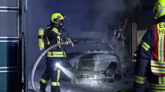 Feuerwehrleute stehen vor einem ausgebrannten Auto in Edewecht. © TeleNewsNetwork 