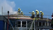 Einsatzkräfte der Feuerwehr löschen einen Brand am Dach der Mensa in Edewecht. © Nord-West-Media TV 