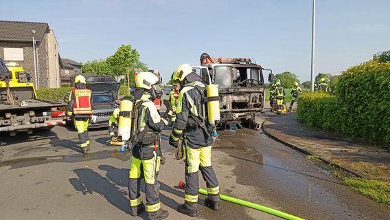 Feuerwehrleute löschen einen Kleinlaster nach einem Unfall mit einem Stromkasten. © Nord-West-Media TV 