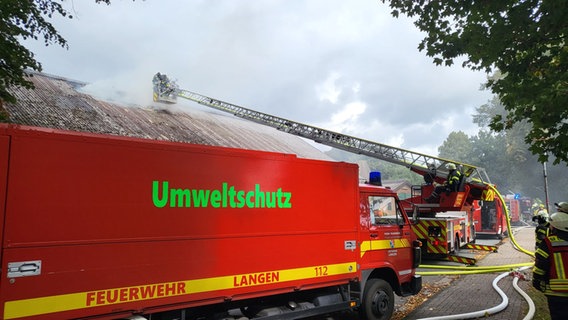 Feuerwehrfahrzeuge stehen vor einem brennenden Gebäude. © Polizei Cuxhaven 