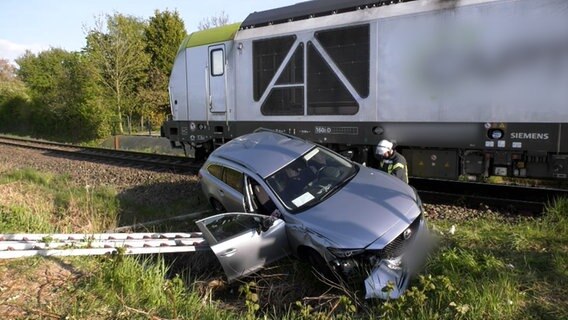 Ein Pkw liegt nach einem Unfall neben einem Zug in einem Graben. © Nonstopnews 