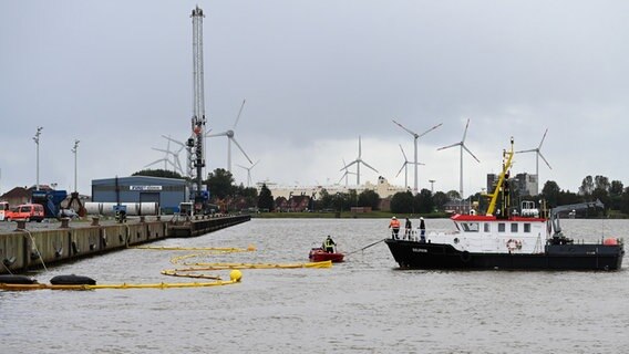Emden: Die Feuerwehr bringt mit Hilfe von zwei Schiffen Ölsperren im Hafen aus. © dpa-Bildfunk Foto: Lars Penning