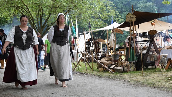 Zwei mittelalterlich gekleidete Frauen gehen Barfuß einen Weg entlang. © dpa - Bildfunk Foto: Carmen Jaspersen