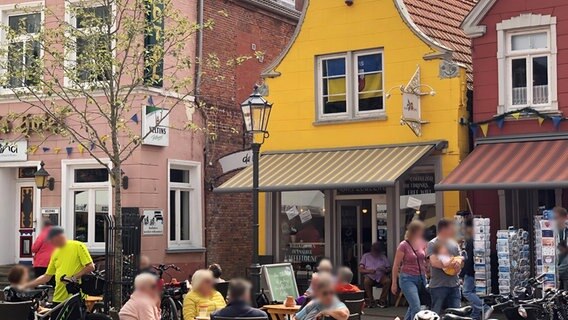 Gäste sitzen bei sommerlichem Wetter vor einem Café in Esens. © NDR Foto: Thomas Stahlberg