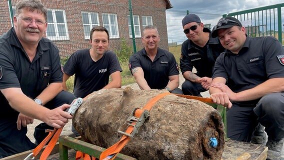 Ein Team des Kampfmittelbeseitigungsdienstes posiert hinter einer Fliegerbombe. © Stadt Oldenburg 