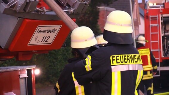 Einsatzkräfte der Feuerwehr stehen vor mehreren Einsatzfahrzeugen. © Nord-West-Media TV 