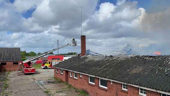Feuerwehrleute bei Löscharbeiten im Einsatz mit einem Kran Feuerwehrleute bei Löscharbeiten im Einsatz mit einem Kran © Feuerwehr Aurich
