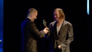 Lars Eidinger bei einer Preisverleihung auf der Bühne des Filmfests in Emden. © NDR 