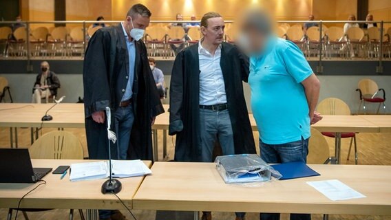 Ein Angeklagter steht mit seinen Anwälten in einem Gerichtssaal. © picture alliance/dpa/Sina Schuldt Foto: Sina Schuldt