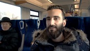 Basel Taifour sitzt in einem Zug und gibt ein Interview. © NDR 