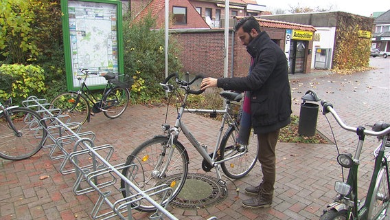 Basel Taifour stellt ein Fahrrad an einen Fahrradständer. © NDR Foto: Silke Rudolph