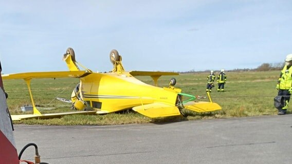 Ein historisches Flugzeug liegt an einer Unfallstelle auf dem Kopf. © Feuerwehr Landkreis Leer 