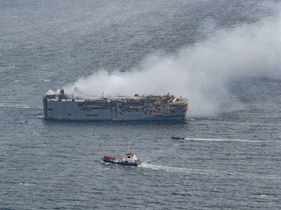 Brennender Autofrachter aus Schifffahrtsroute gezogen