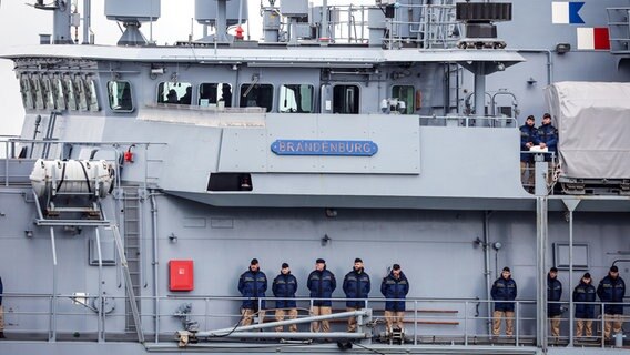 Marinesoldaten und -soldatinnen stehen bei ihrer Rückkehr aus dem Mittelmeer an Deck der Fregatte "Brandenburg" (F215). © dpa Foto: Focke Strangmann