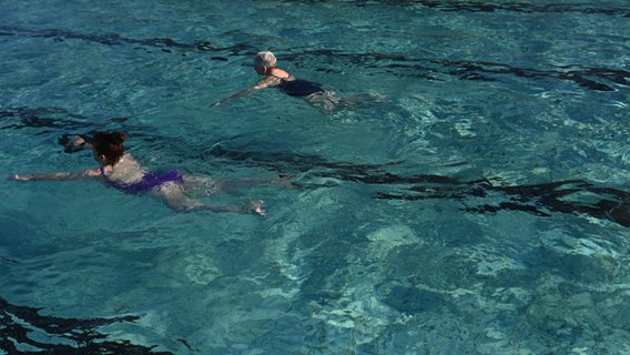 Zwei Frauen schwimmen in einem Freibad in Weener. © dpa Foto: Lars Penning