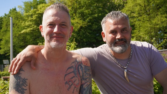 Zwei Männer sitzen in einem Freibad nebeneinander. Zwei Männer sitzen in einem Freibad nebeneinander. © NDR Foto: Lotti Höfer