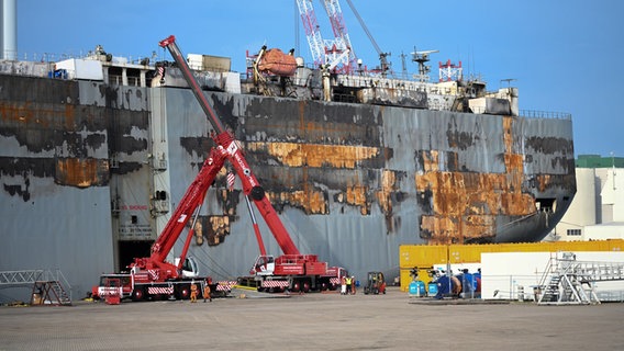 Die schwer beschädigte "Fremantle Highway" liegt im Hafen von Eemshaven. Mithilfe von zwei Kränen wird der Autofrachter entladen. © picture alliance/dpa Foto: Lars Penning