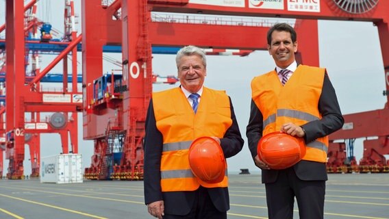 Bundespräsident Joachim Gauck (l) geht gemeinsam mit Olaf Lies (SPD), Niedersächsischer Minister für Wirtschaft, Arbeit und Verkehr beim Besuch des JadeWeserPort an den Containerbrücken vorbei. © picture alliance / dpa Foto: Carmen Jaspersen