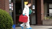Eine Beamtin der Spurensicherung packt ihre Sachen vor einer Bank in der ein Geldautomat gesprengt wurde. © Nord-West-Media TV 