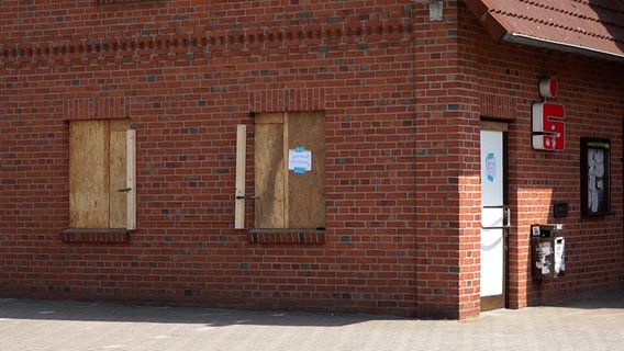Nachdem Unbekannte in Kirchlinteln einen Geldautomaten gesprengt haben, sind Fenster an einem Bankgebäude mit Sperrholz ersetzt, Schilder weisen darauf hin, dass die Sparkasse geschlossen ist.. © Nord-West-Media TV 